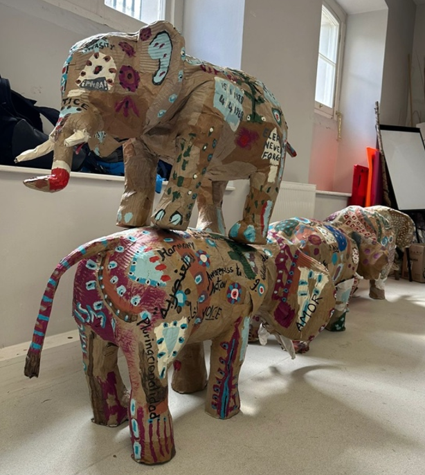 Finished paper elephants, one on top of a line